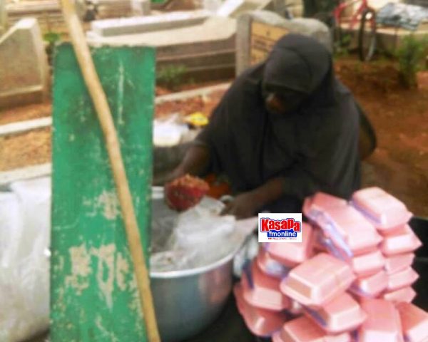 Woman packages food for sale at Awudome Cemetery