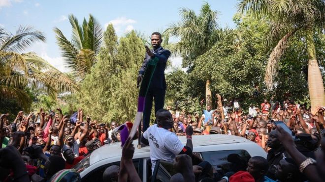 Bobi Wine spoke atop a vehicle to jubilant crowds outside his home 