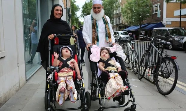 Safa and Marwa Ullah leave hospital with their mother and their grandfather. Photograph: Great Ormond Street Hospital/PA