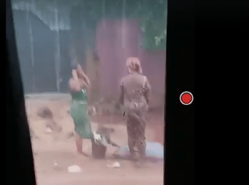 Ladies dumping rubbish on road during downpour