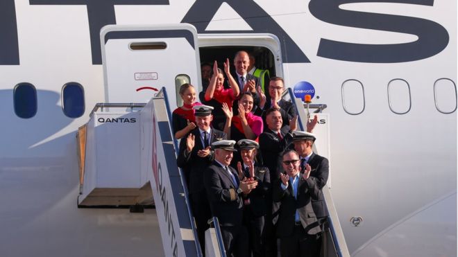 All smiles: Qantas crew celebrate after the 19-hour journey from New York to Sydney