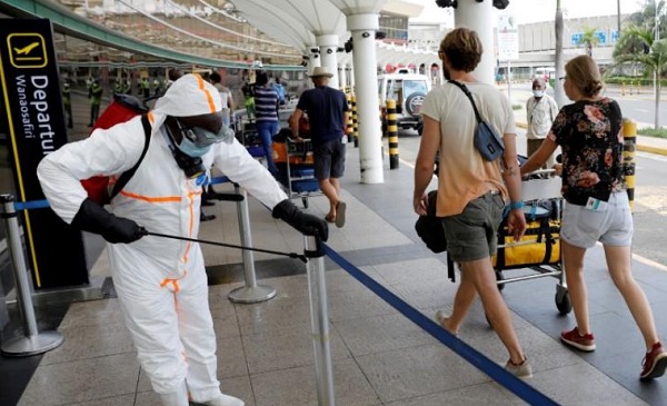 A health worker sprays disinfectant to prevent an outbreak of the coronavirus disease (COVID-19) at the Jomo Kenyatta International Airport in Nairobi, Kenya, March 24, 2020. REUTERS/Baz Ratner