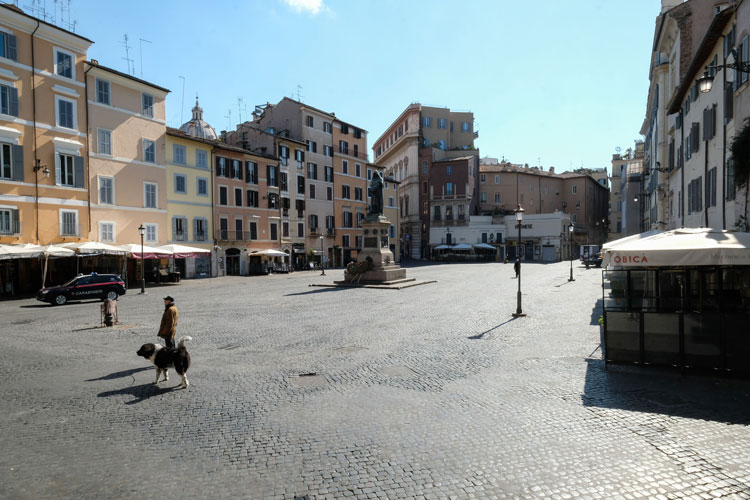 A man walks his dog across a deserted Piazza Campo dei Fiori in central Rome on March 24 during Italy's lockdown aimed at stopping the spread of the coronavirus pandemic. Andreas Solaro/AFP/Getty Images