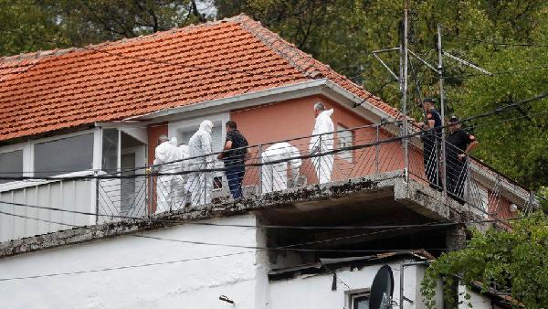 A police forensic unit inspects the house where the mass shooting began in the city of Cetinje
