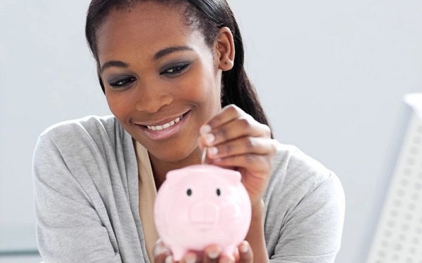 Woman putting money in a piggy bank