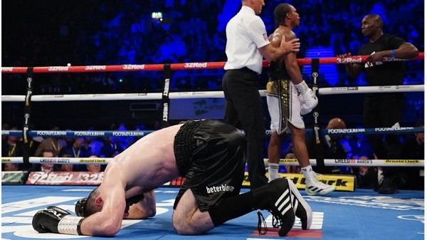 Artur Beterbiev celebrates by dropping to the canvas as the referee calls off the fight after Anthony Yarde's corner threw the towel in